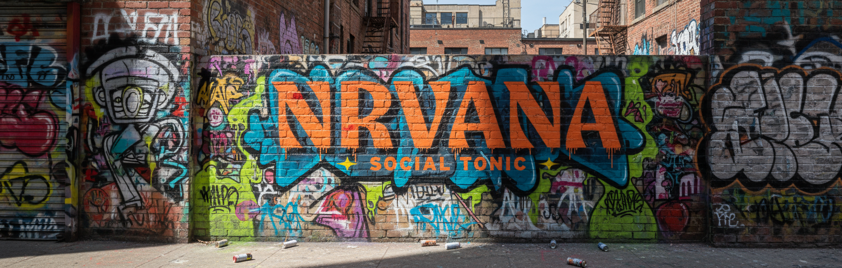 Colorful graffiti mural with bold NRVANA Social Tonic logo painted on brick wall in urban alley.